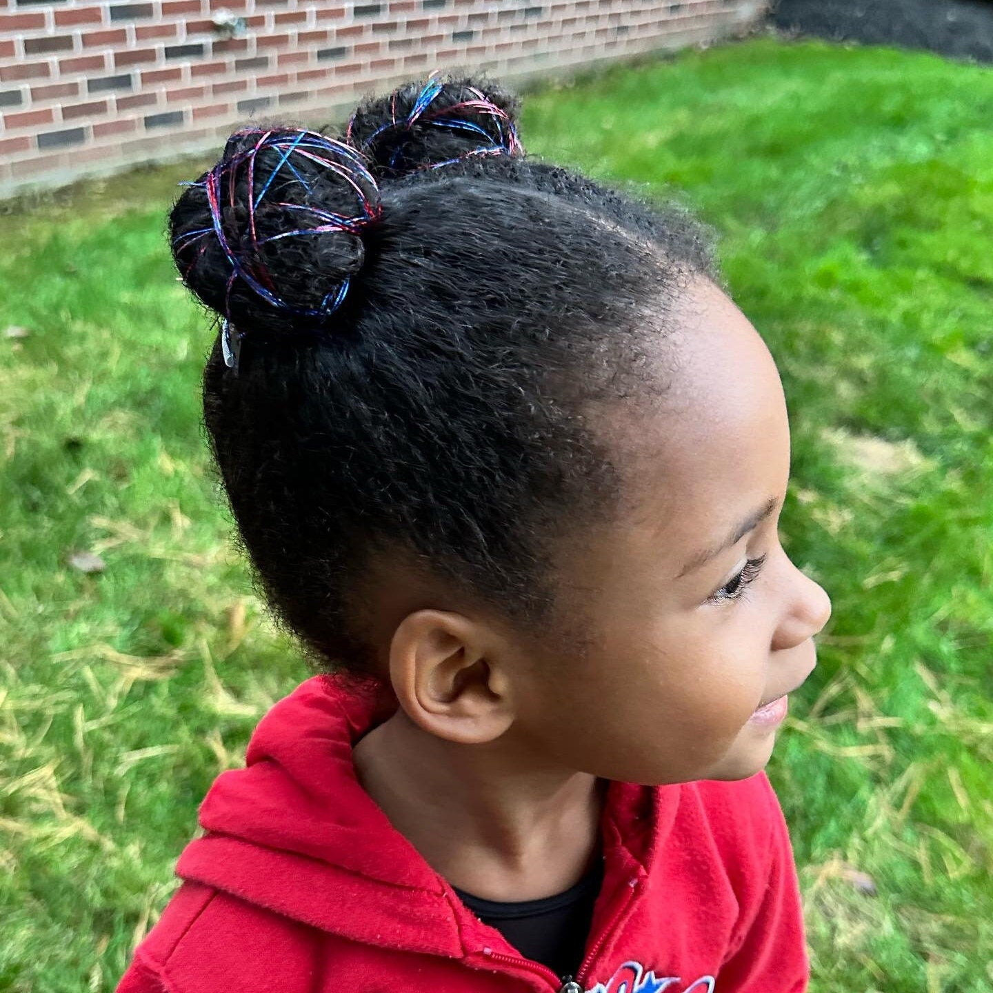 Girl wearing hair tinsel clips matching Philadelphia Phillies Baseball Colors