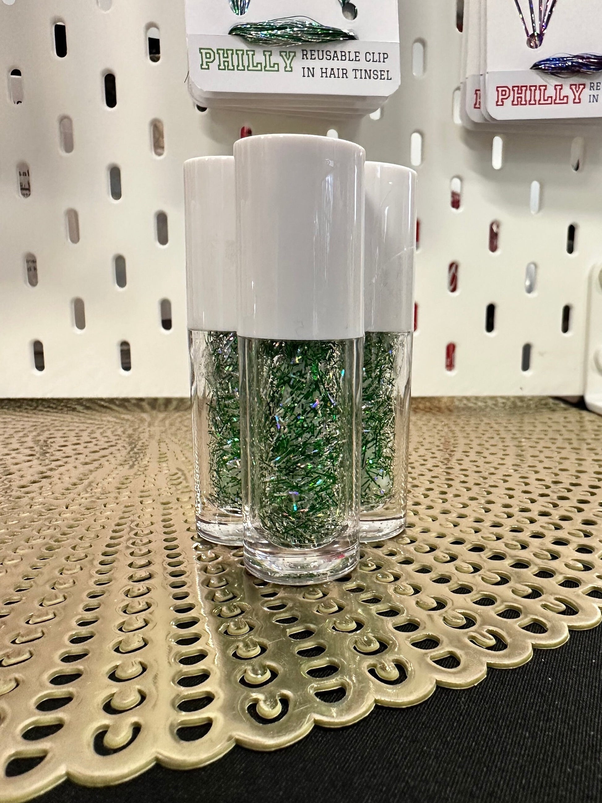 This shows three bottles of silver and green mixed tinsel gel, perfect to match team colors, sports colors, school colors, bachelorette parties and more.  The tubes hold 6ml of medium hold sparkle tinsel hair gel.