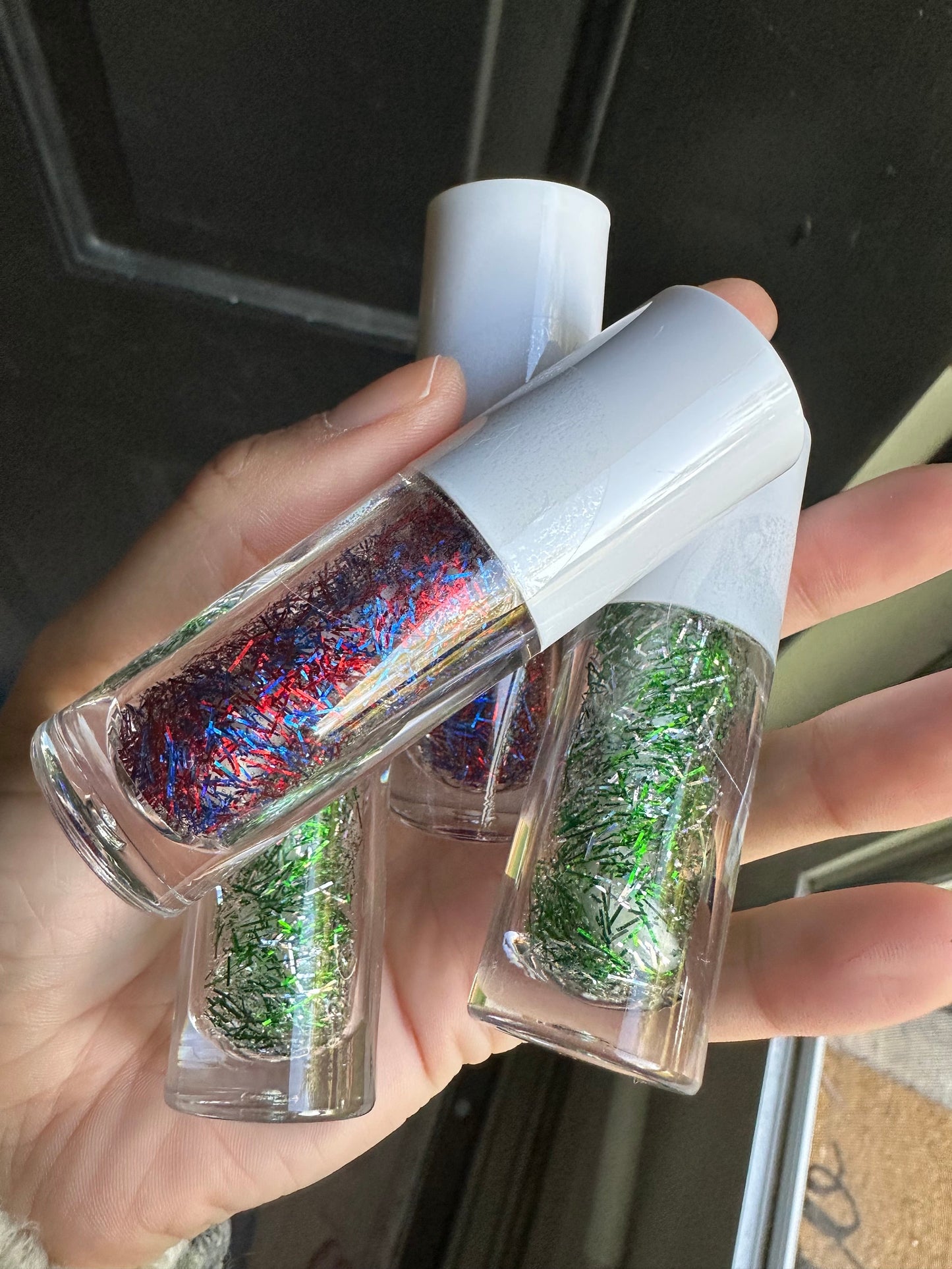 Hands holding bottles of WildMane tinsel hair gel.  Glitter gel for hair adds instant sparkle with no mess.  Alcohol free, water based sparkly gel for festivals, concerts, dress up and every day wear.