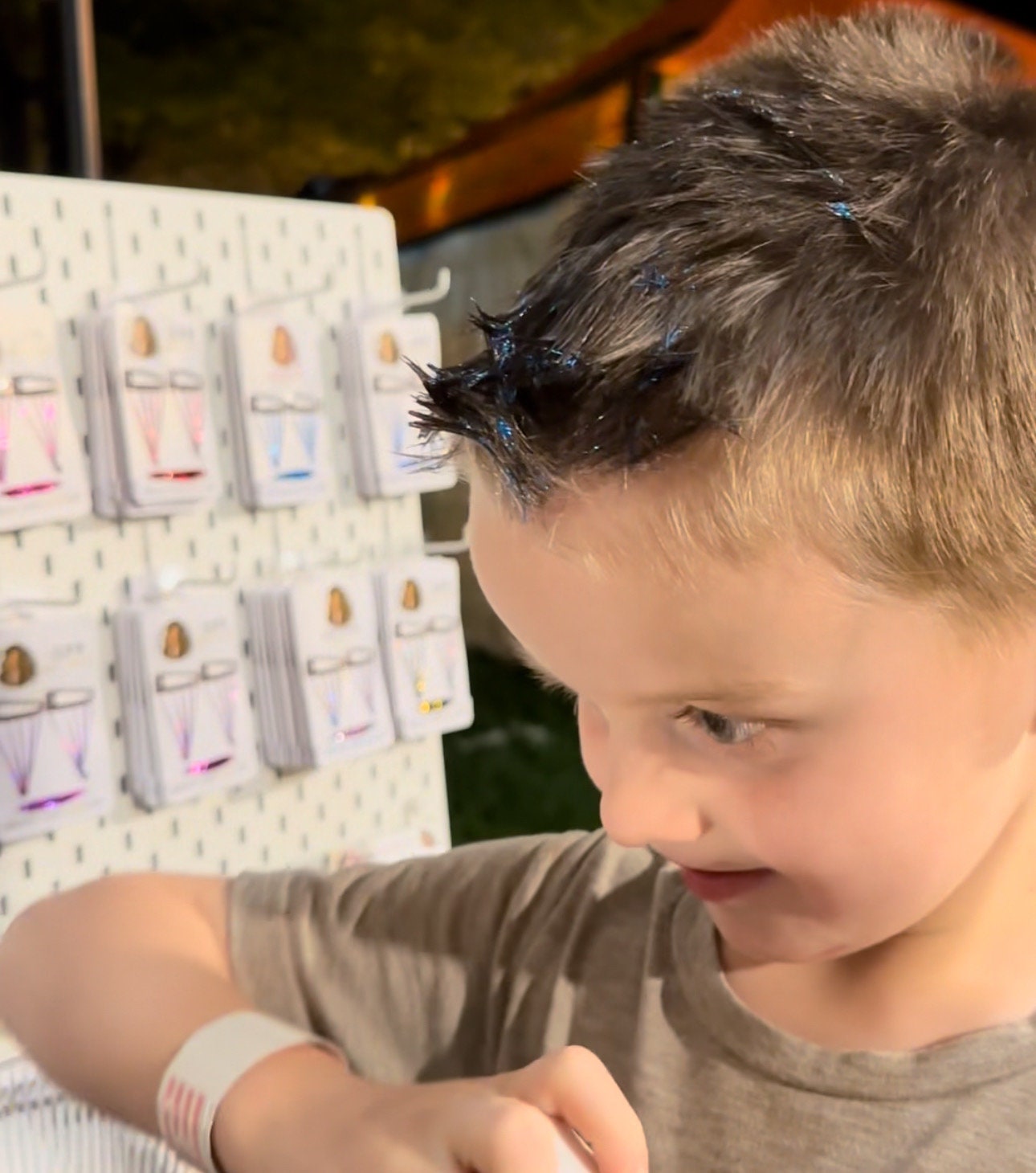 A four year old boy applies arctic blue tinsel gel to his hair easily by himself. WildMane tinsel gel is perfect for any hair length and any gender.  The medium hold gel can be used to style your hair and also add instant color and shimmer!