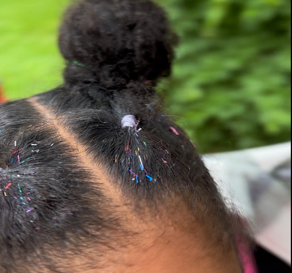 A 5 year old child poses with rainbow vivid tinsel hair gel in their pulled back hair style. WildMane tinsel hair gel is great for any hairstyle, including styles using small rubber bands.  The gel is perfect for all hair textures, straight or curly.