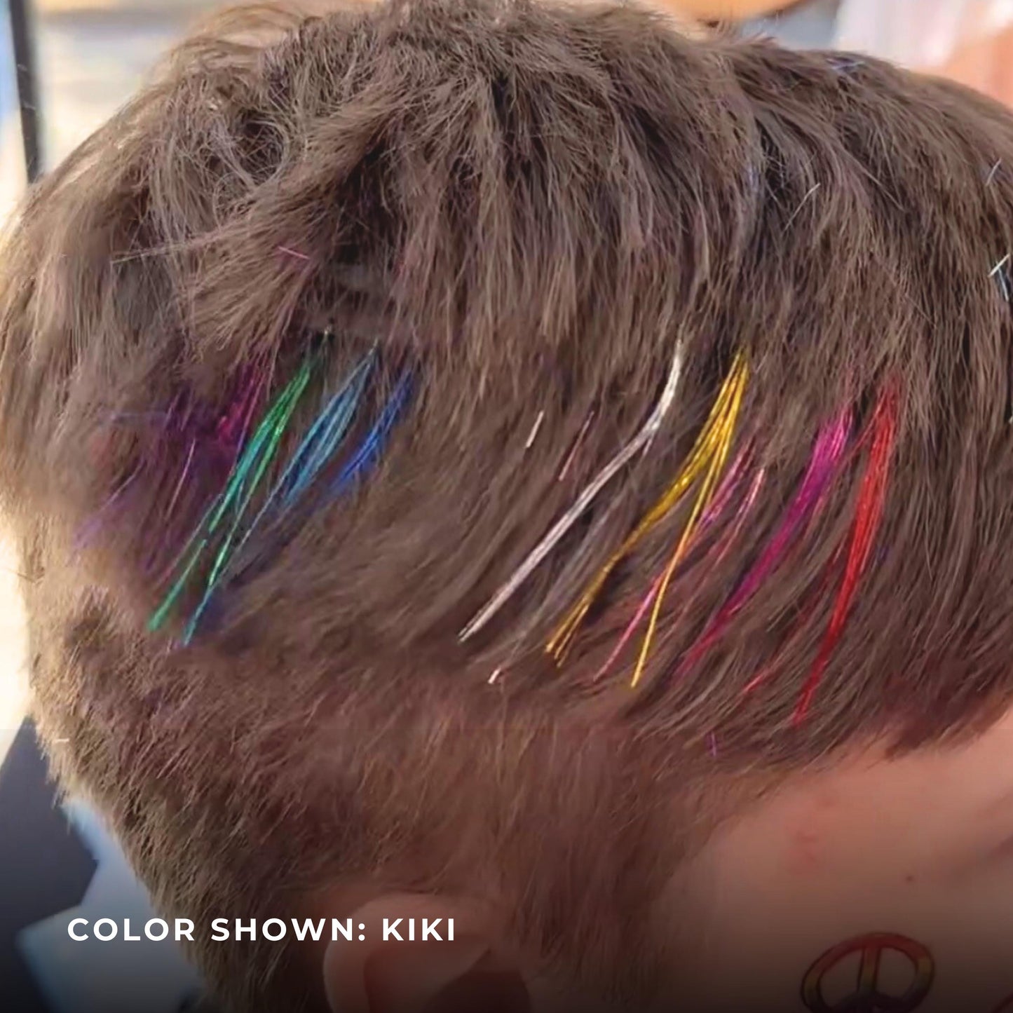 Close up of rainbow tinsel hair clip in color all tea on teen boy.  Pride fest kids and teens hair accessories.